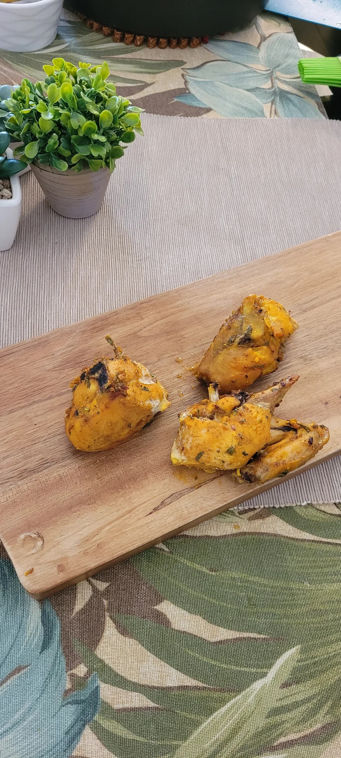 Cooked seasoned chicken pieces on a wooden board